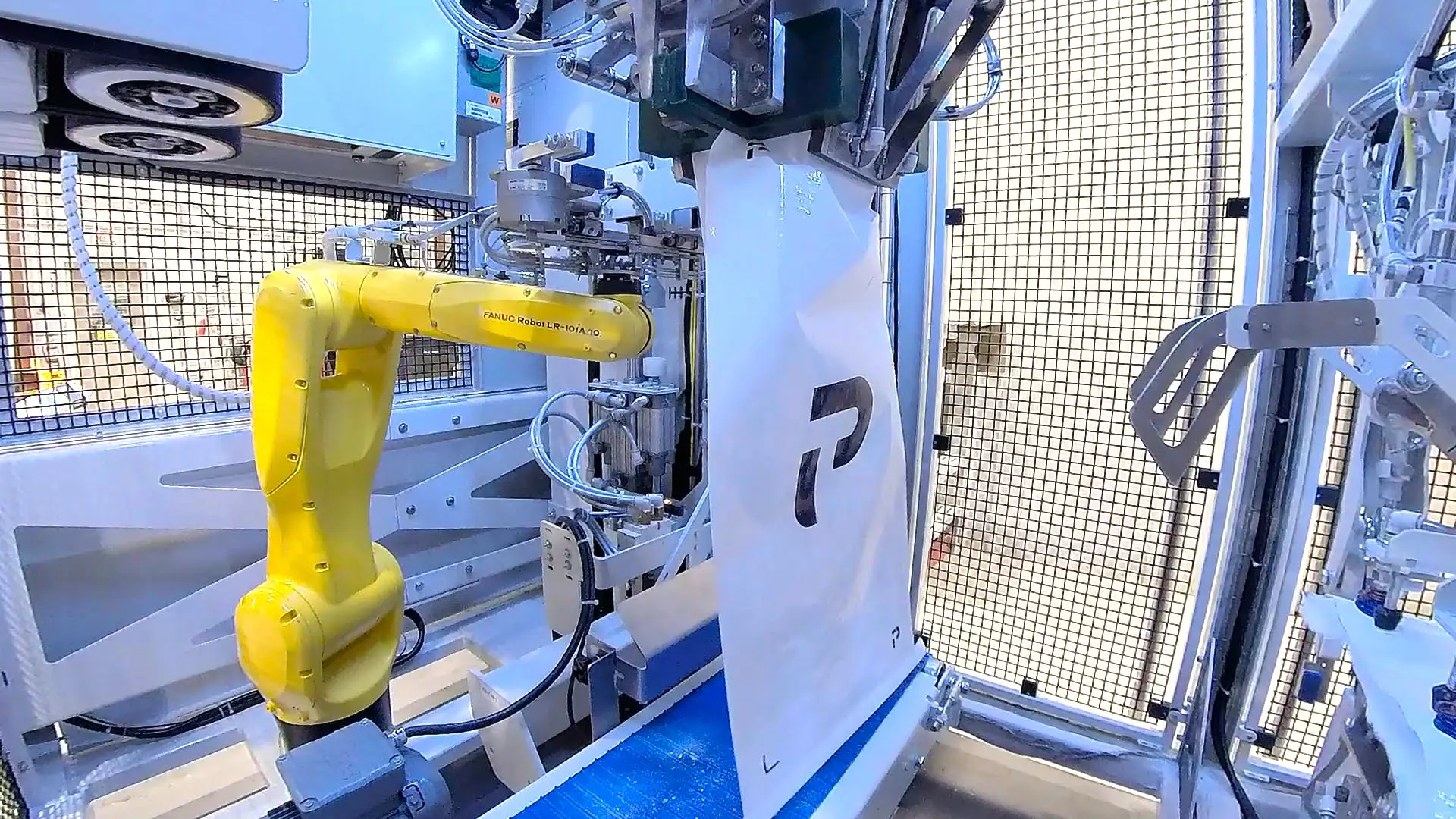 open-mouth-omr-1100-robot Robot inside the CHRONOS OMR bagging machine