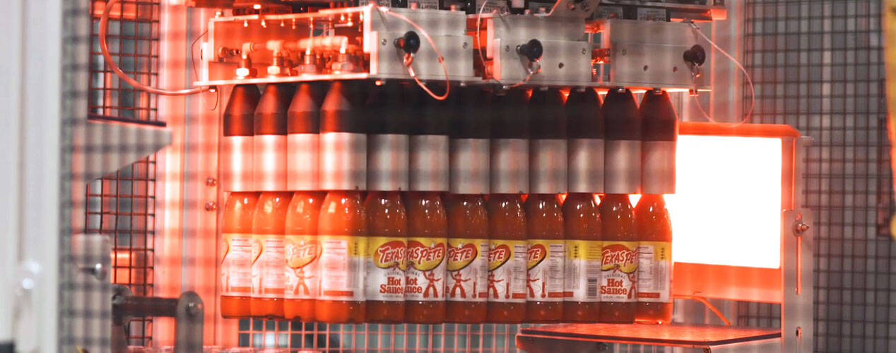TW Garner hot sauce bottles being packaged into trays by Premier Tech equipment