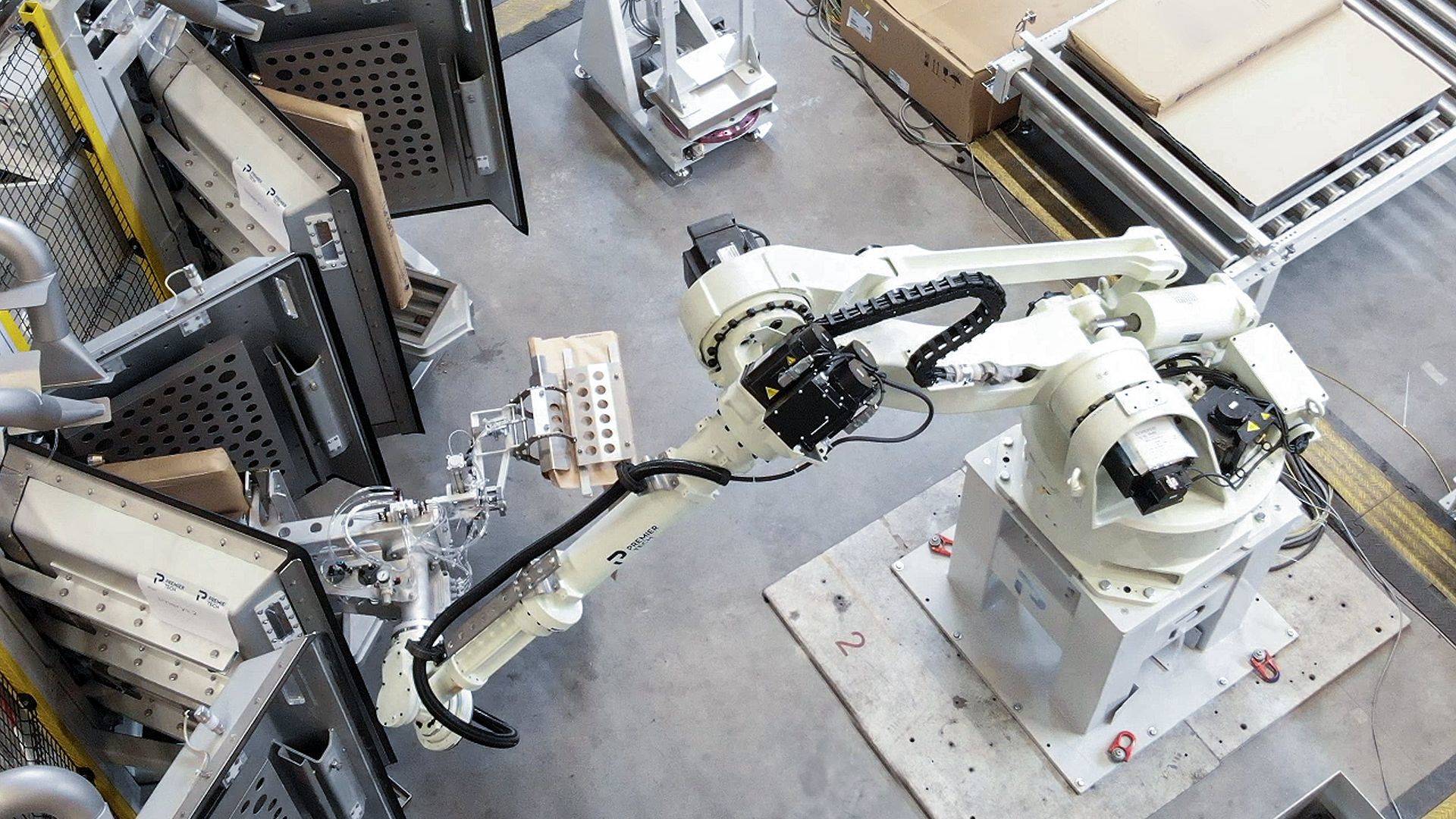 A robot removes a filled valve bag from a vacuum packer