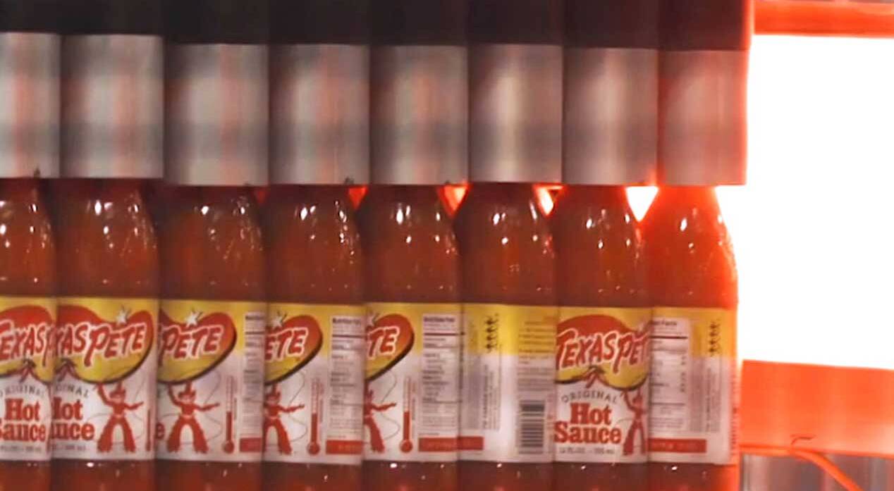 TW Garner hot sauce bottles being packaged into trays by Premier Tech equipment