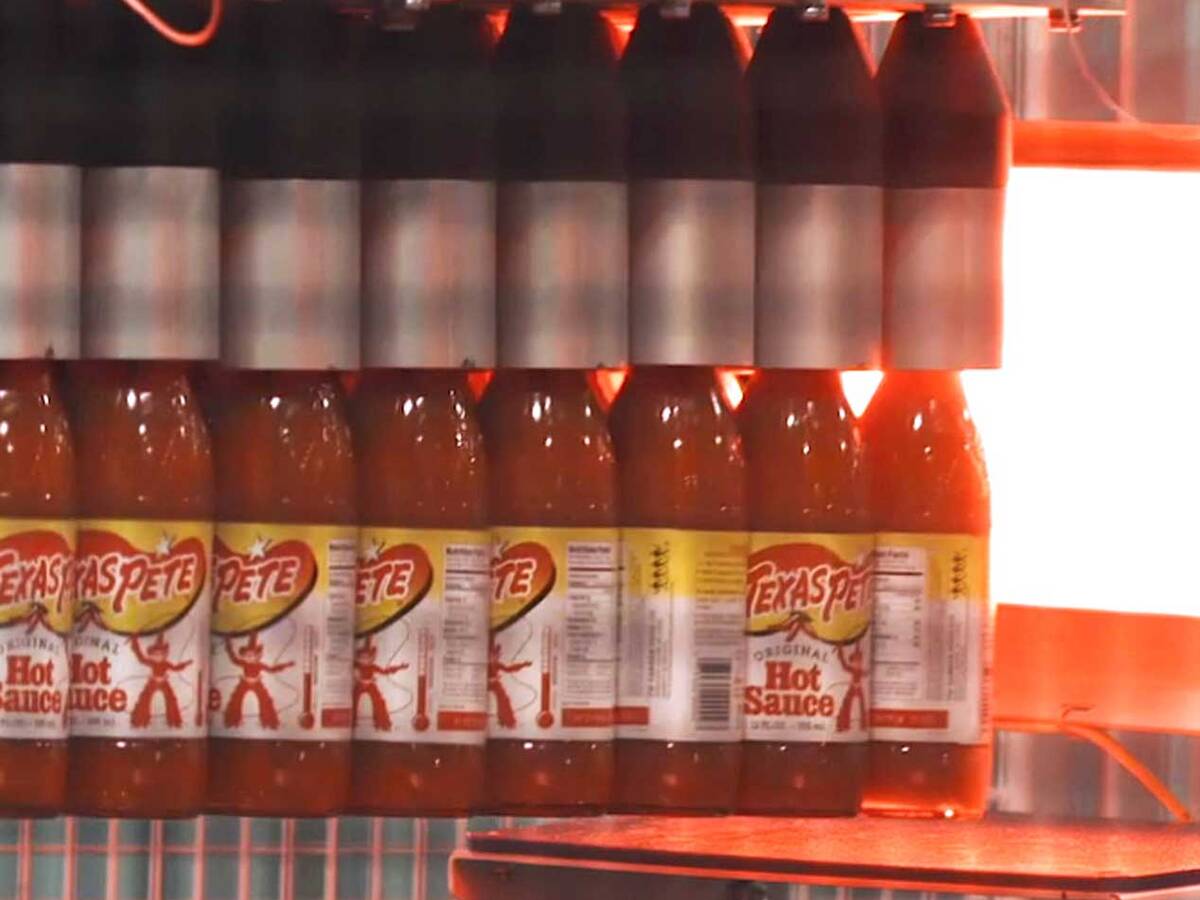 TW Garner hot sauce bottles being packaged into trays by Premier Tech equipment