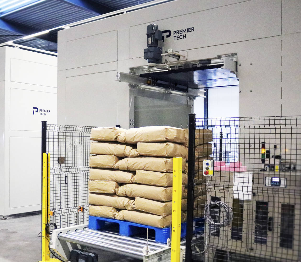 A pallet load of flour bags exits a conventional palletizer