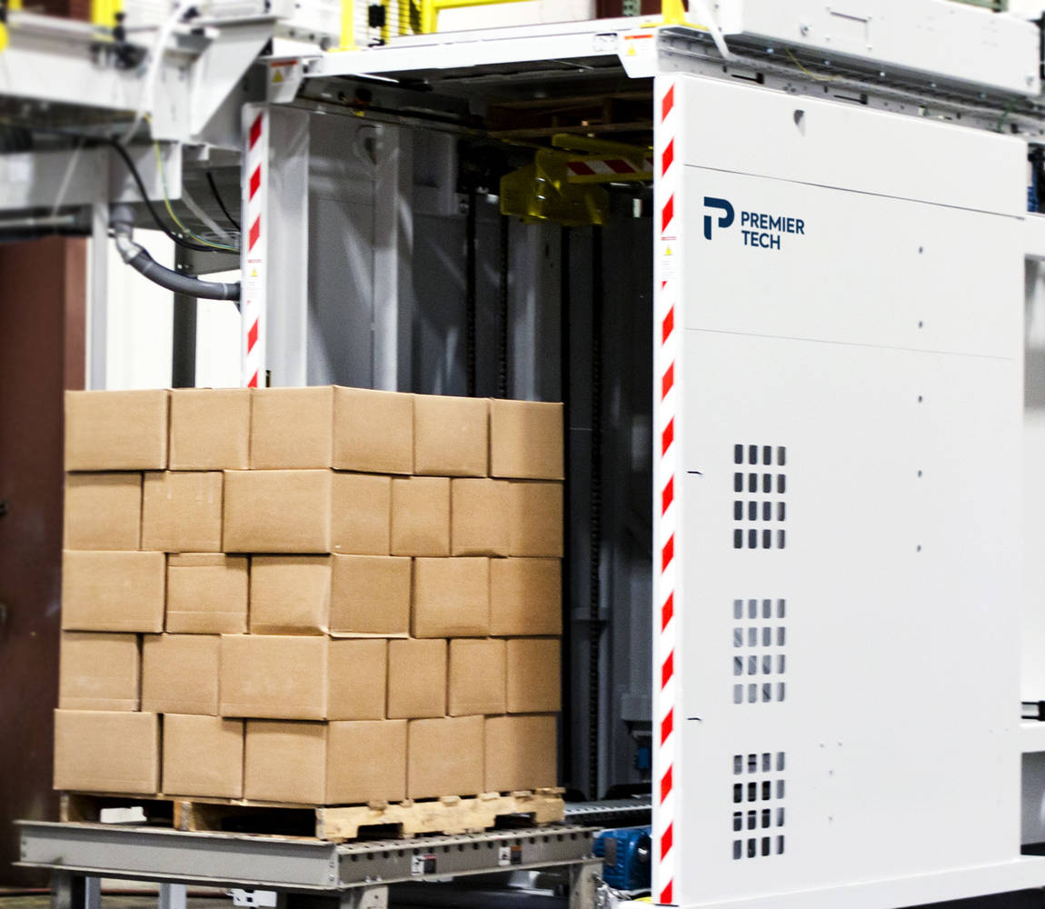 Carton boxes stacked on a pallet exit a conventional palletizer