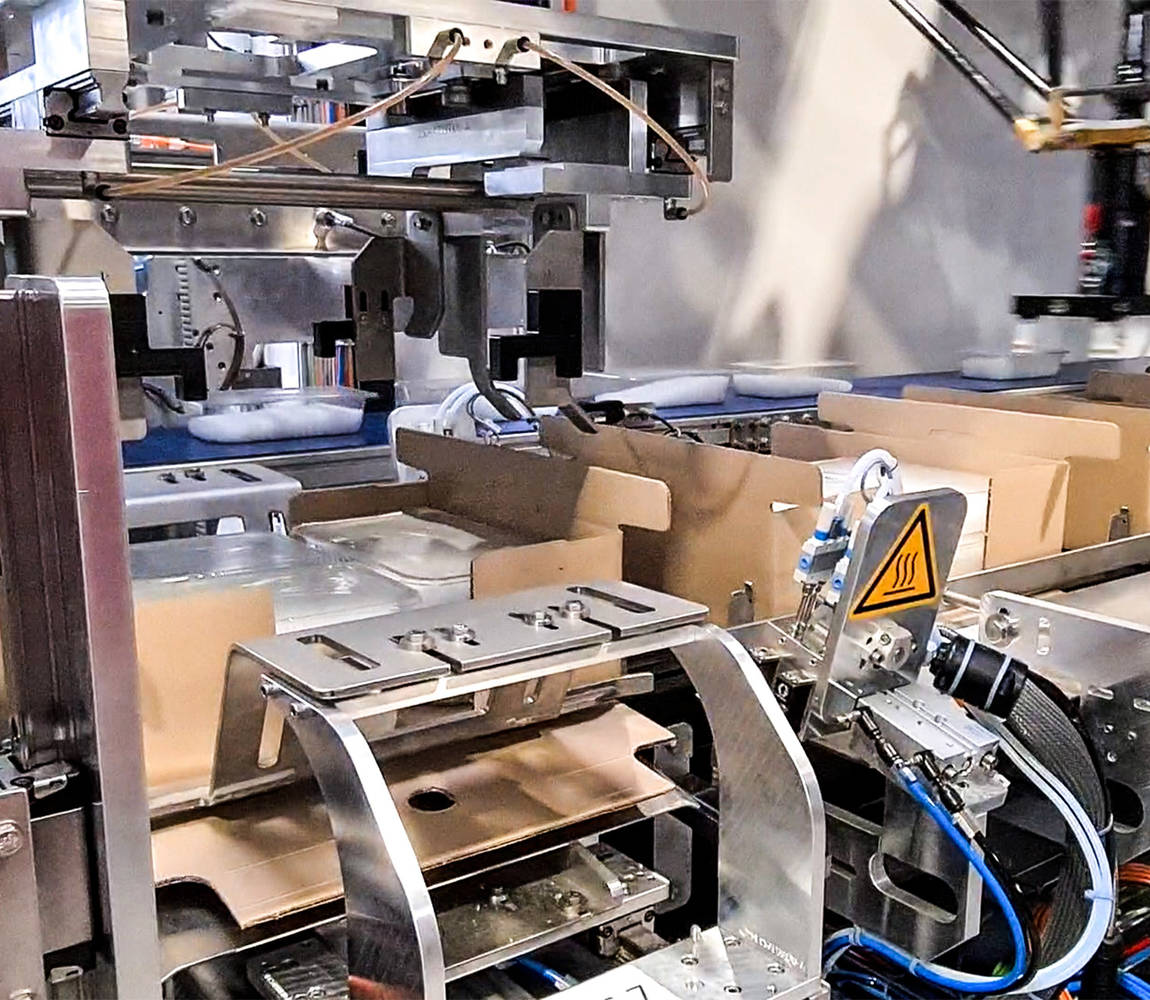 Wrap around case packer - box closing