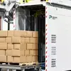 Carton boxes stacked on a pallet exit a conventional palletizer