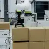 Close up on TOMA cobot arm lifting a box