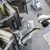 A robot removes a filled valve bag from a vacuum packer