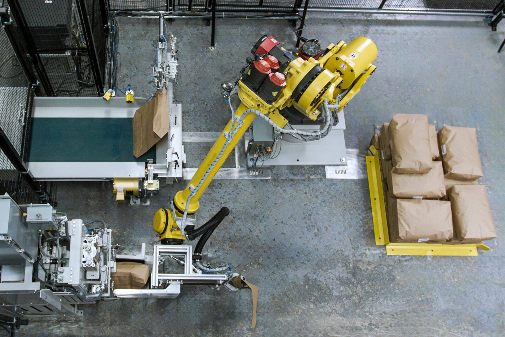 A robot places a valve bag on a valve bag filler