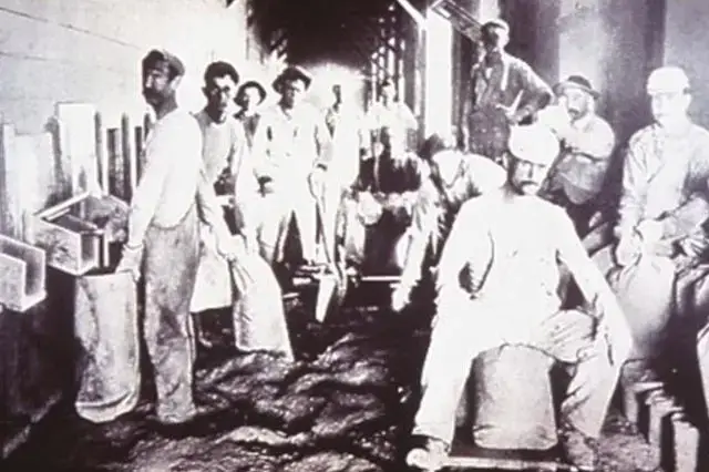 Workers manually bagging product in the early 1900s