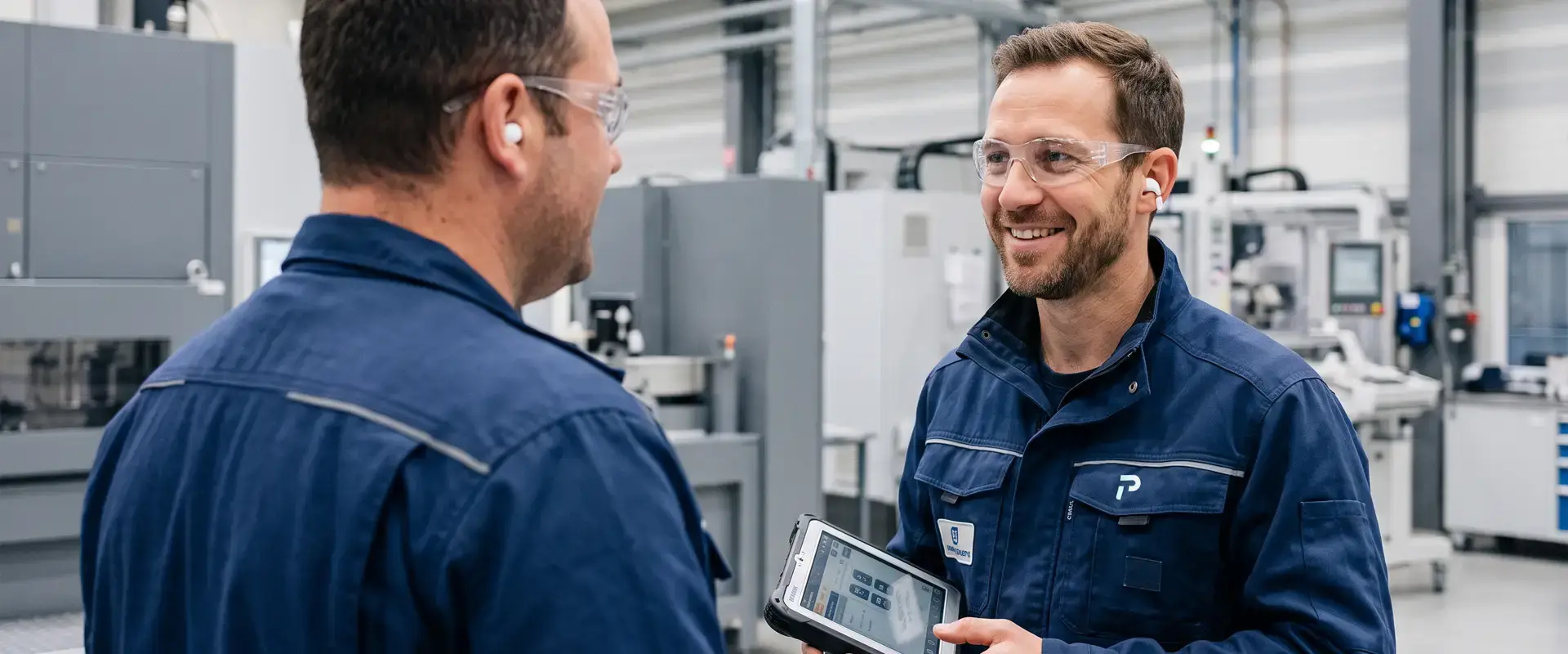 Two operators in a manufacturing plant with a Premier Tech equipment