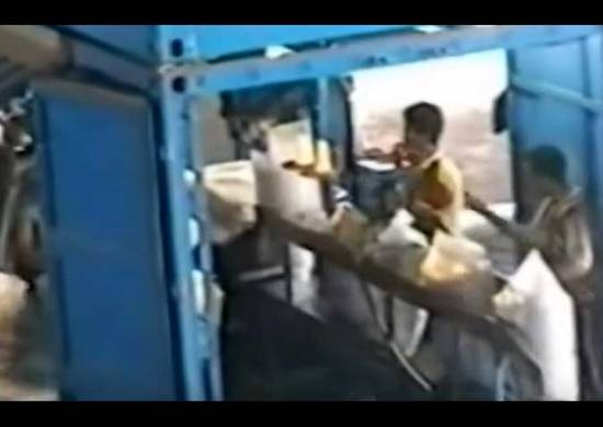 People handling bags on a manual bagging machine